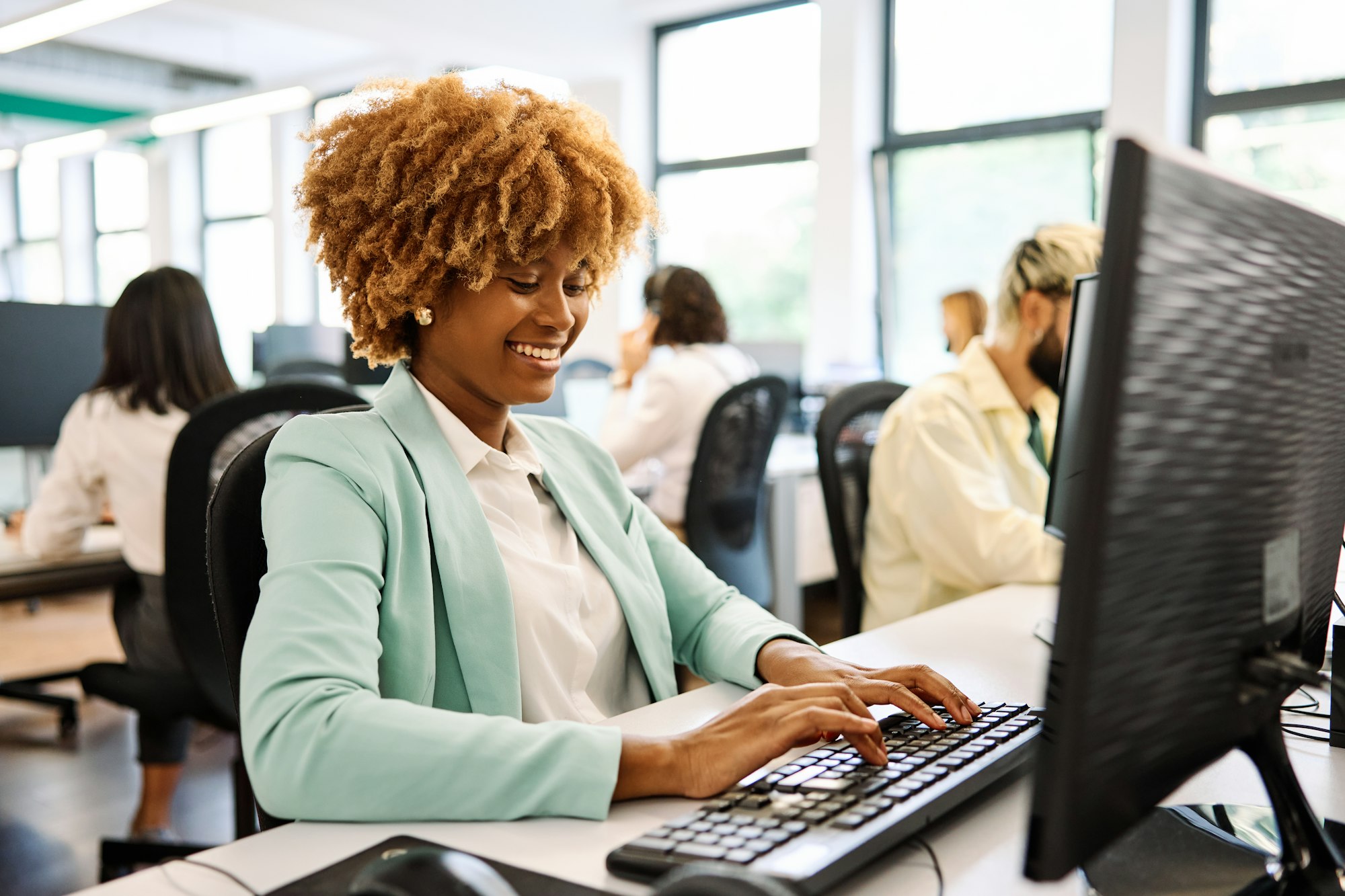 African woman using laptop working in a coworking